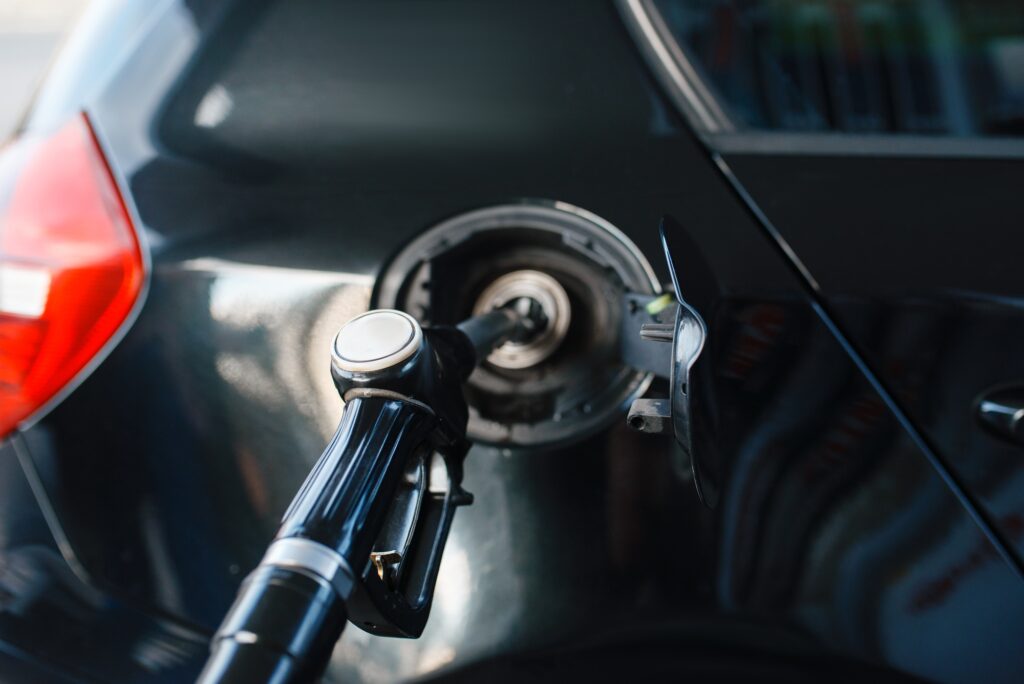 Car with gun in tank fueling on gas station
